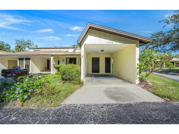 Light yellow exterior condo with carport and landscaped lawn at 6906 Woodwind Dr # 12, Sarasota, FL 34231