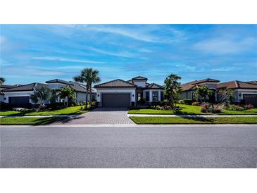 Single-story home with tile roof, gray garage door, and landscaped yard at 5307 Cicerone St, Sarasota, FL 34238