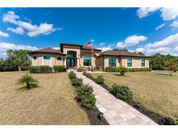 Single-story home with a walkway leading to the front door, and a landscaped lawn at 8939 E River Rd, Venice, FL 34293