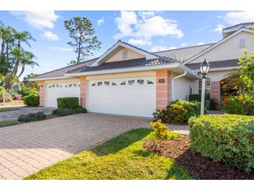 Two-car garage and inviting entryway of a charming villa at 1119 Lynx Run, North Port, FL 34288