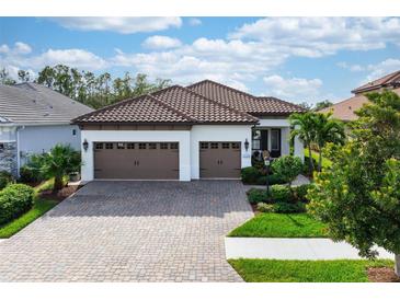 Two-car garage, paver driveway, and lush landscaping enhance this home's curb appeal at 11945 Hunters Creek Rd, Venice, FL 34293