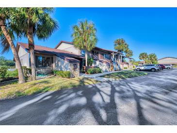 Two-story condo building with palm trees and parking at 927 Capri Isles Blvd # 5, Venice, FL 34292