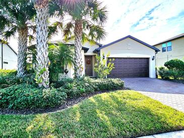 Charming single-story home with a well-manicured lawn and beautiful palm tree landscaping in front at 2501 Sherman Oak Dr, North Port, FL 34289