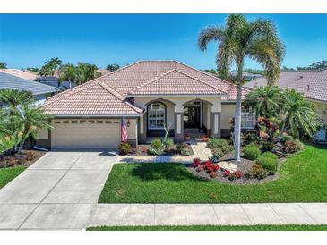 Single-story home with tile roof, landscaped yard, and two-car garage at 2878 Egret Ct, North Port, FL 34287