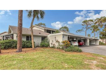 Exterior view of condo with carport and landscaping at 405 Pinebrook Cres # 5, Venice, FL 34285