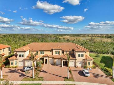 A charming multi-Gathering home boasts a tile roof, garages, and a beautifully landscaped yard at 10039 Crooked Creek Dr # 203, Venice, FL 34293