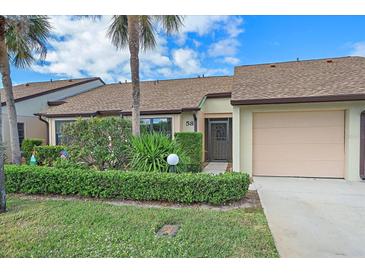 Inviting front yard with lush landscaping and attached garage at 1211 Capri Isles Blvd # 58, Venice, FL 34292