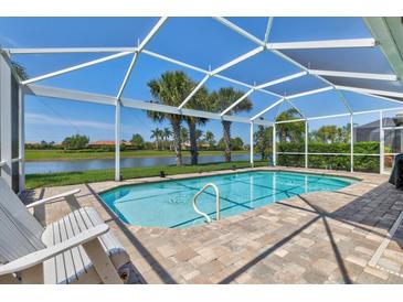 Private pool with a screened enclosure, lounge chairs, and a view of the lake at 19225 Jacinda St, Venice, FL 34293