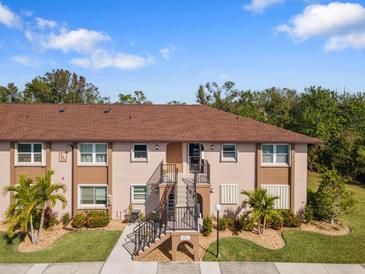 Condo building with brown roof and landscaping at 25100 Sandhill Blvd # K-204, Punta Gorda, FL 33983