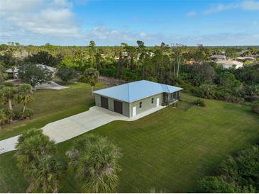 Aerial view of single-story home with two-car garage and spacious yard at 4130 Rock Creek Dr, Port Charlotte, FL 33948