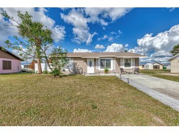 Cute one-story house with a landscaped lawn and driveway at 13540 Dibella Ave, Port Charlotte, FL 33981