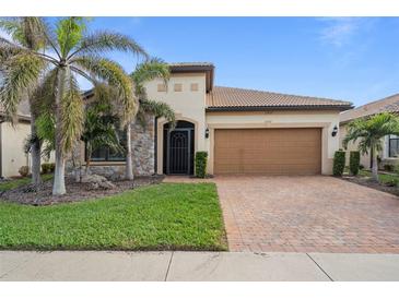 Single-story home with attractive landscaping and a two-car garage at 13807 Karina St, Venice, FL 34293