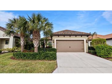 Single-story home with brown garage door and landscaping at 287 Cassano Dr, Nokomis, FL 34275