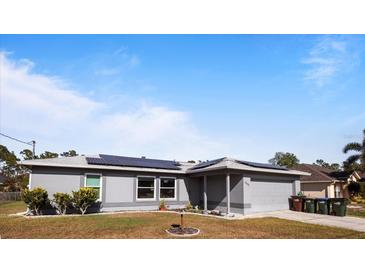 Gray house with solar panels and a landscaped yard at 4666 La Rosa Ave, North Port, FL 34286