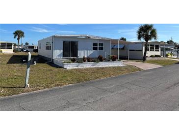 Mobile home exterior with driveway, landscaping, and palm trees at 708 Roma Rd, Venice, FL 34285