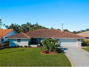 Single-story home with terracotta tile roof and landscaped lawn at 1678 Quail Lake Dr, Venice, FL 34293