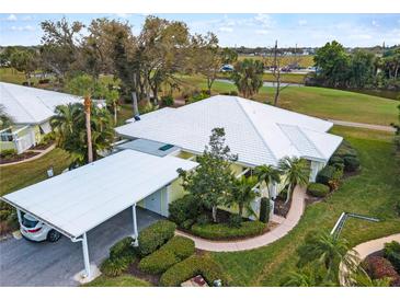 Aerial view of condo with carport, landscaping, and golf course view at 324 Wexford Ter # 171, Venice, FL 34293