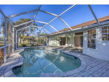 Inviting screened-in pool area with brick-paved deck offers a relaxing outdoor living space at 2899 Ensenada Ln, North Port, FL 34286