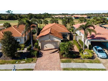 Charming single-story home features a brick driveway, terra cotta roof, and tropical landscaping at 482 Montelluna Dr, North Venice, FL 34275