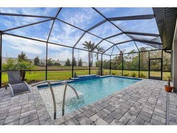 Screened-in pool featuring a waterfall feature, tiled flooring, and seating area at 19807 Bridgetown Loop, Venice, FL 34293