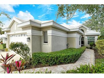 Charming single-story home features a white tile roof and lush landscaping at 560 Fallbrook Dr, Venice, FL 34292