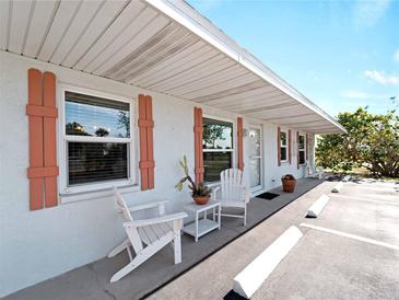 Charming condo featuring a cozy seating area with stylish wooden chairs and coral-colored shutters, inviting relaxation at 1423 Avenida Del Circo # 1C, Venice, FL 34285