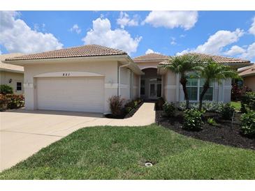 Charming single-story home with manicured lawn, lush landscaping, and a well-maintained tile roof at 651 Lakescene Dr, Venice, FL 34293