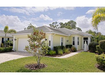 Charming single-story home featuring lush landscaping, manicured lawn, and a paved walkway to the front entrance at 11053 Barnsley Dr, Venice, FL 34293