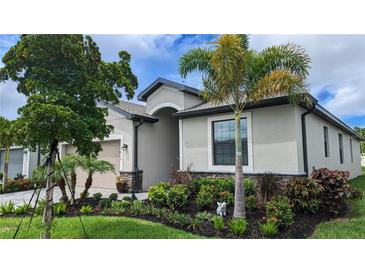 Charming single-story home featuring lush landscaping, a well-manicured lawn, and a welcoming facade at 19716 Fishhawk Trl, Venice, FL 34293