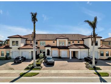 Spacious condos with terracotta tile roofs and paved driveways, perfect for relaxed community living with tropical landscaping at 23108 Banbury Way # 202, Venice, FL 34293