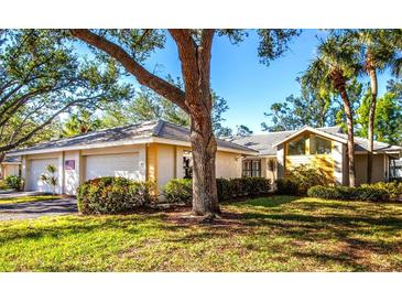 Charming single-story home featuring mature trees, lush landscaping, and a two-car garage at 237 Southampton Ln # 275, Venice, FL 34293