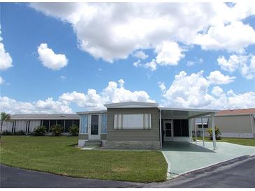Charming single-story home with carport and green lawn under a partly cloudy sky at 476 Boxwood Dr, Venice, FL 34285