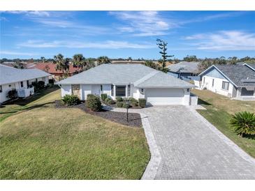 Charming single-story home featuring a brick-paved driveway, well-manicured lawn, and pristine landscaping at 5838 Tyler Rd, Venice, FL 34293