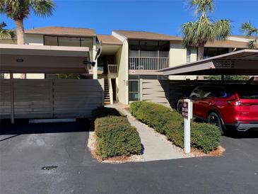 Condo exterior featuring assigned covered parking and a landscaped walkway to the front entrance at 634 Bird Bay E Dr # 103, Venice, FL 34285