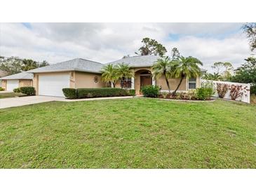 Charming single-story home featuring a well-maintained lawn, tasteful landscaping, and a two-car garage at 1422 Evangelina Ln, North Port, FL 34286