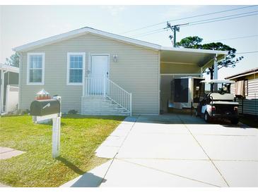 Charming single-story home with well-maintained lawn and a convenient carport with a golf cart at 242 Blackburn Blvd, North Port, FL 34287