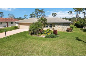 Well-maintained single-story home with a large manicured lawn and lovely landscaping at 407 Rubens Dr, Nokomis, FL 34275