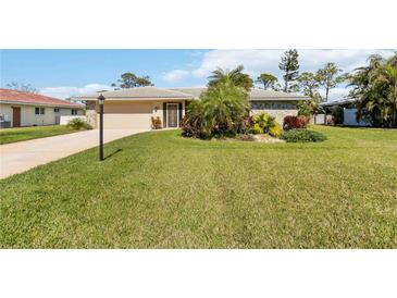 Charming single-story home featuring a well-manicured lawn and mature landscaping at 407 Rubens Dr, Nokomis, FL 34275