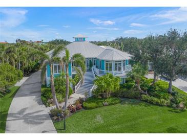 Beautiful two-story home with lush landscaping, covered porches and a metal roof at 746 Eagle Point Dr, Venice, FL 34285