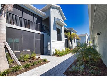 Exterior view showcasing well-maintained grounds, screened-in patios, and a serene walkway in a peaceful setting at 12580 Galapagos Ct # 107, Venice, FL 34293