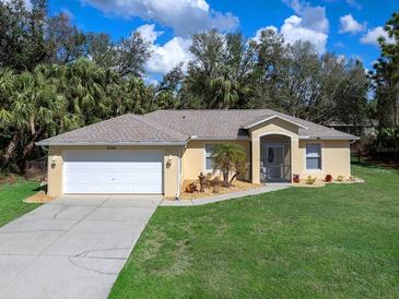 Charming one-story home features a two-car garage and well-manicured lawn with garden at 3348 Trapper Ln, North Port, FL 34286