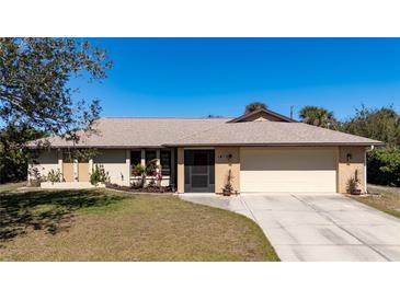 Charming single-story home with a well-maintained lawn, neutral paint, and a two car attached garage at 11208 Grafton Ave, Englewood, FL 34224