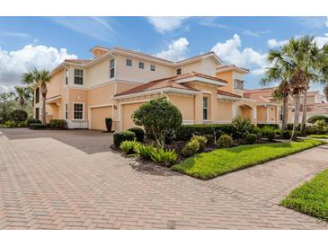 Beautiful Mediterranean-style home with a brick driveway and lush landscaping at 142 Bella Vista Ter # A, North Venice, FL 34275