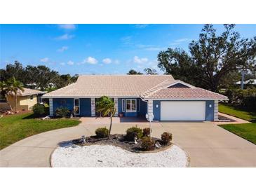 Charming single-Gathering home features a two-car garage, circular drive, and beautiful landscaping at 2 Windsor Dr, Englewood, FL 34223