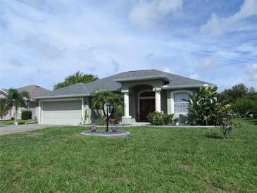 Charming one-story home featuring a two-car garage and well-manicured landscaping at 2115 Pan American Blvd, North Port, FL 34287