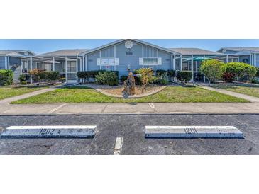 Charming condo exterior with landscaped front yard and assigned parking spaces for easy access at 3300 Loveland Blvd # 1201, Punta Gorda, FL 33980