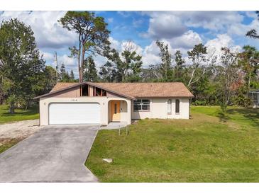 Charming single-story home with a garage, cream-colored paint, and a spacious front yard at 3716 Dunbar Rd, Venice, FL 34293