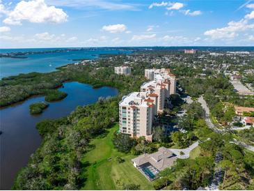 Stunning aerial view of the luxury waterfront condos surrounded by lush greenery and bay waters at 385 N Point Rd # 404, Osprey, FL 34229