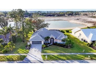 Charming home with well-manicured lawn, mature trees, and beautiful lake view at 5051 Greenway Dr, North Port, FL 34287