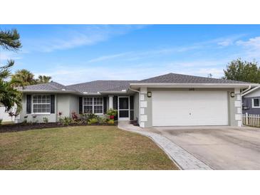 Charming single-story home boasts a lush front yard with vibrant landscaping and an attached two-car garage at 648 Cypress Rd, Venice, FL 34293